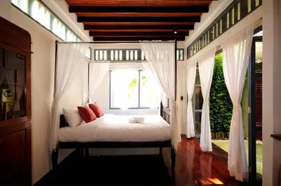 a bedroom with a canopy bed with a window at Baan Noppawong in Bangkok
