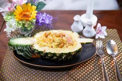 a black plate with an avocado on a table at The Tarntawan Hotel Surawong Bangkok in Bangkok