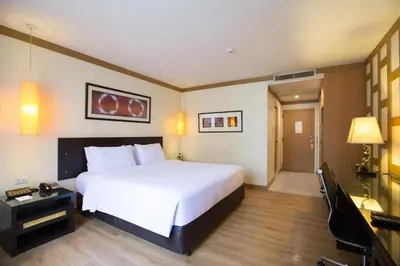 a hotel room with a bed and a television at The Tarntawan Hotel Surawong Bangkok in Bangkok