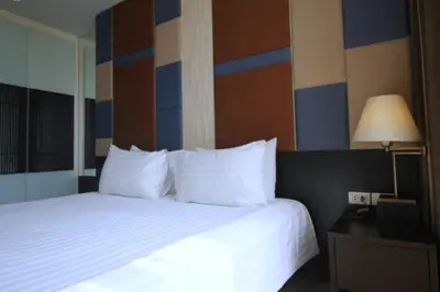 a hotel room with a bed with white pillows at The Sunreno Hotel Bangkok in Bangkok