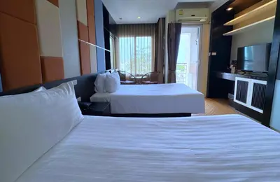 a hotel room with two beds and a television at The Sunreno Hotel Bangkok in Bangkok