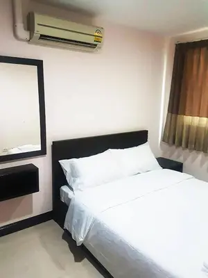 a bedroom with a white bed and a air conditioner at Mok Mek 72 in Bangkok