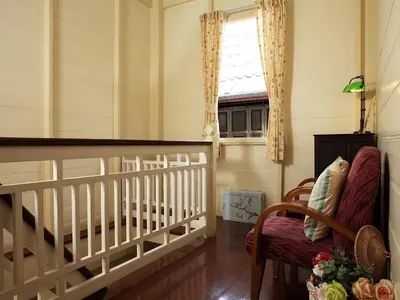 a room with a crib and a chair and a window at Baan Dinso in Bangkok