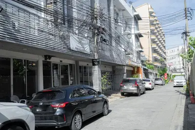 a street with cars parked in front of a building at Ratchadamnoen Residence in Bangkok