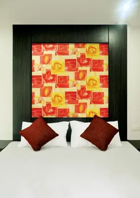 a bed with two pillows and a painting on the wall at DB Plus 1 in Bangkok