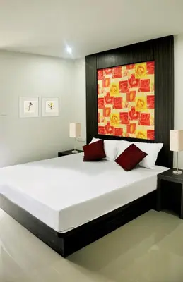 a bedroom with a large bed with a painting on the wall at DB Plus 1 in Bangkok