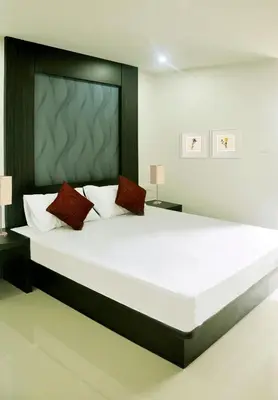 a bedroom with a large white bed with red pillows at DB Plus 1 in Bangkok