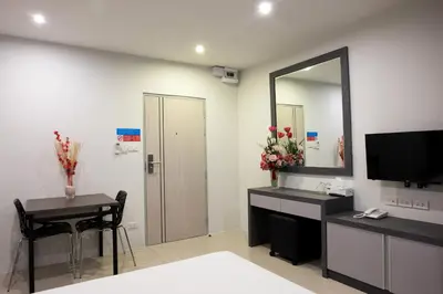 a bathroom with a mirror and a sink and a table at DB Plus 5 in Bangkok