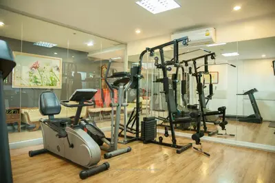 a gym with several treadmills and exercise bikes at Nara Suite Residence Bangkok in Bangkok