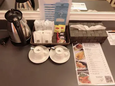 a table with two cups and plates and a tea pot at Westgate Residence Hotel in Ban Bang Kho