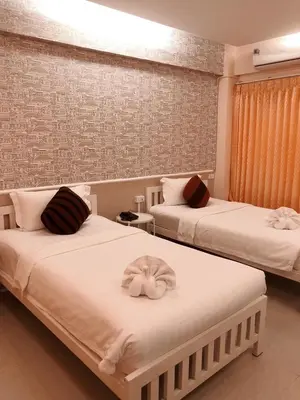 a bedroom with two beds with white sheets at Westgate Residence Hotel in Ban Bang Kho