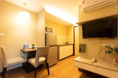 a small room with a dining table and a kitchen at Greenview Ekkamai10 Suite in Bangkok