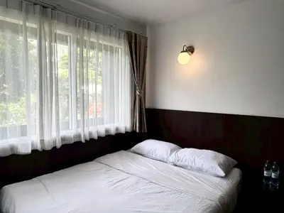 a bed in a room with a large window at Four Sisters Homestay in Bangkok