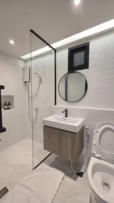 a bathroom with a sink and a mirror and a toilet at Wang Lang Hostel in Bangkok