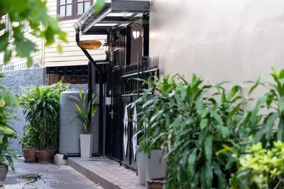 a black gate in front of a house with plants at Sawatdee Guesthouse the Original in Bangkok