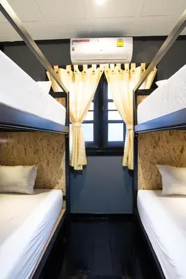 two bunk beds in a room with a window at Sawatdee Guesthouse the Original in Bangkok