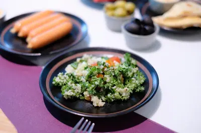 a plate of food with broccoli and carrots on a table at Aspira Skyy Sukhumvit 1 in Bangkok