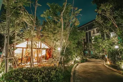 a house with a pavilion in the woods at night at Bangkok Oasis Hotel in Bangkok