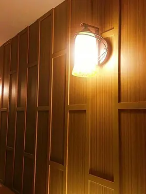 a light is attached to a wooden wall at King Royal Garden Inn in Bangkok