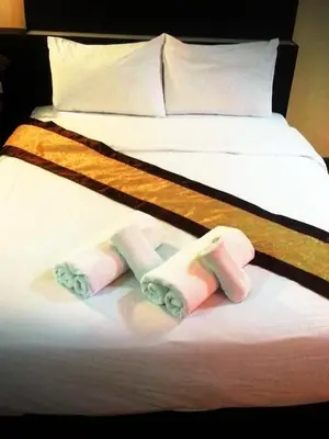 two beds with folded towels on the bed at King Royal Garden Inn in Bangkok