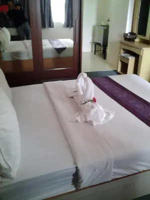 a hotel room with a bed with a towel on it at King Royal 2 in Bangkok