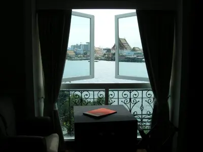 a window with a view of the water from a balcony at Aurum The River Place in Bangkok