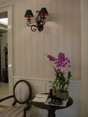 a table with a vase of purple flowers on it at Aurum The River Place in Bangkok