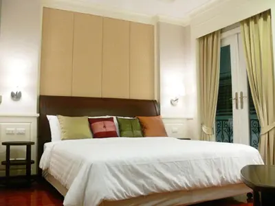 a bedroom with a large white bed with colorful pillows at Aurum The River Place in Bangkok