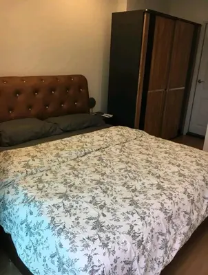 a bedroom with a bed with a floral bedspread at Gsuite Glamorous Apartment in Bangkok