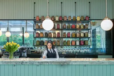 a woman behind the counter of a bar at Oriental Residence Bangkok in Bangkok
