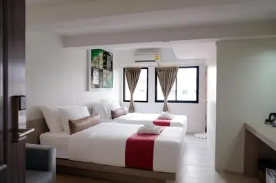 a white bedroom with a white bed and a window at Sawasdee House in Bangkok