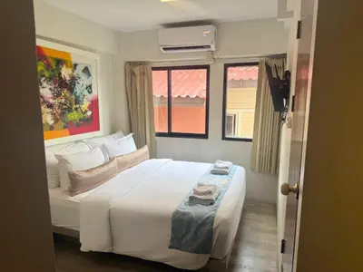 a bedroom with a white bed and a window at Sawasdee House in Bangkok