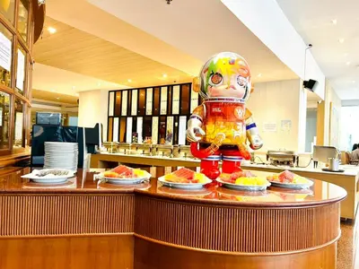 a statue of a person standing at a counter with food at FuramaXclusive Pratunam Park Hotel in Bangkok