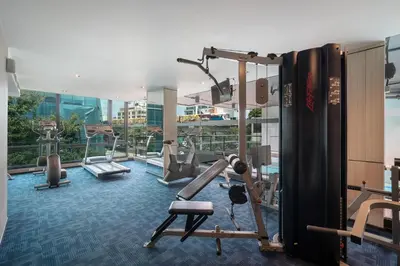 a gym with cardio equipment in a building at VIC 3 Bangkok Hotel in Bangkok