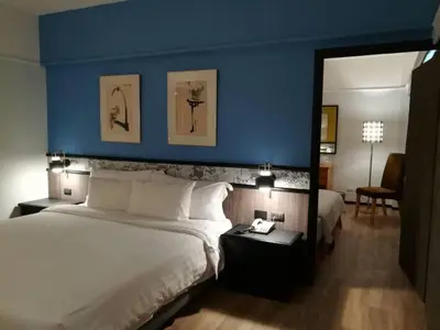 a bedroom with a large bed and a blue wall at Witz Bangkok Ramkhamhaeng in Bangkok