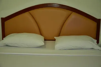 two pillows sitting on a bed with an orange headboard at At Bangkok Hotel in Bangkok