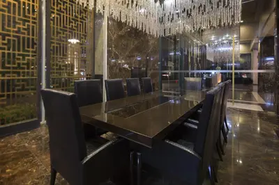 a dining room with a long black table and chairs at Ivy Thonglor 55 in Bangkok