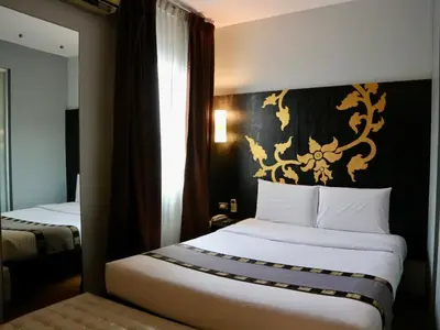 a hotel room with a large white bed in it at Swana Bangkok Hotel in Bangkok