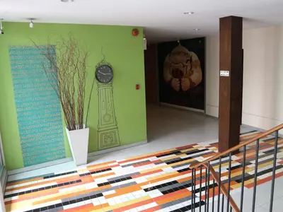 a room with a clock on the wall and a staircase at Swana Bangkok Hotel in Bangkok