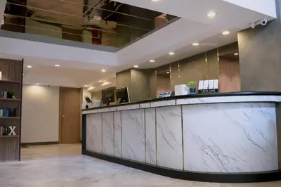 a lobby with a reception counter in a building at Maxim's Inn in Bangkok