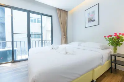 a bedroom with two beds and a large window at Metro hotel in Bangkok