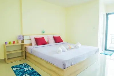 a bedroom with a bed with white sheets and red pillows at Be My Guest 36 in Bangkok