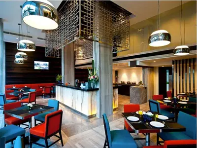 a restaurant with tables and chairs and a bar at FX Hotel Metrolink Makkasan in Bangkok