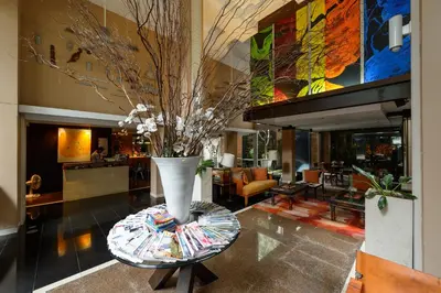 a lobby with a vase with flowers on a table at Silom Convent Garden in Bangkok