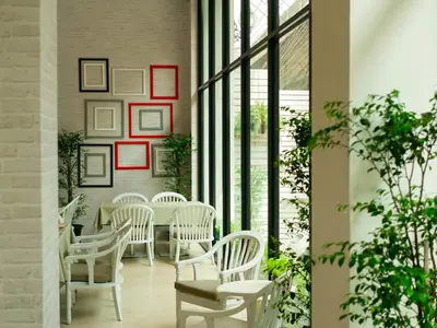 a dining room with white chairs and a table at The Kinn Bangkok in Bangkok