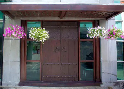 a wooden door with two potted flowers on it at Bansabai Sabaidee Service Apartment in Bangkok