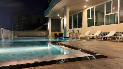 a swimming pool in front of a building at night at Bangkok Patio BTS Sanam Pao in Bangkok