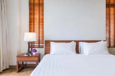 a bedroom with a bed and a table with a lamp at Bangkok Patio BTS Sanam Pao in Bangkok