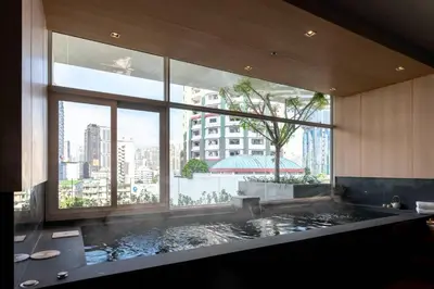 a bathroom with a large window and a large bath tub at Jasmine 59 Hotel in Bangkok