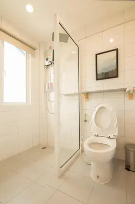 a white bathroom with a shower and a toilet at Ekanake hostel in Bangkok